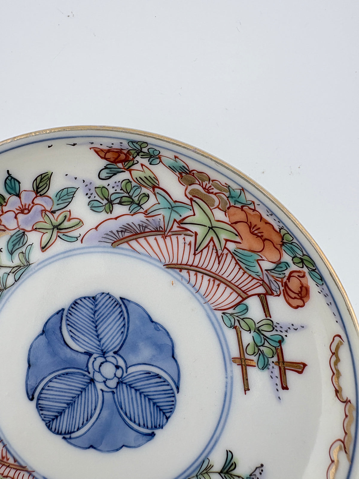 Meiji Imari iroe plate with stylised blossom motif, blue central medallion, and red‑green floral panels – Kotto Living