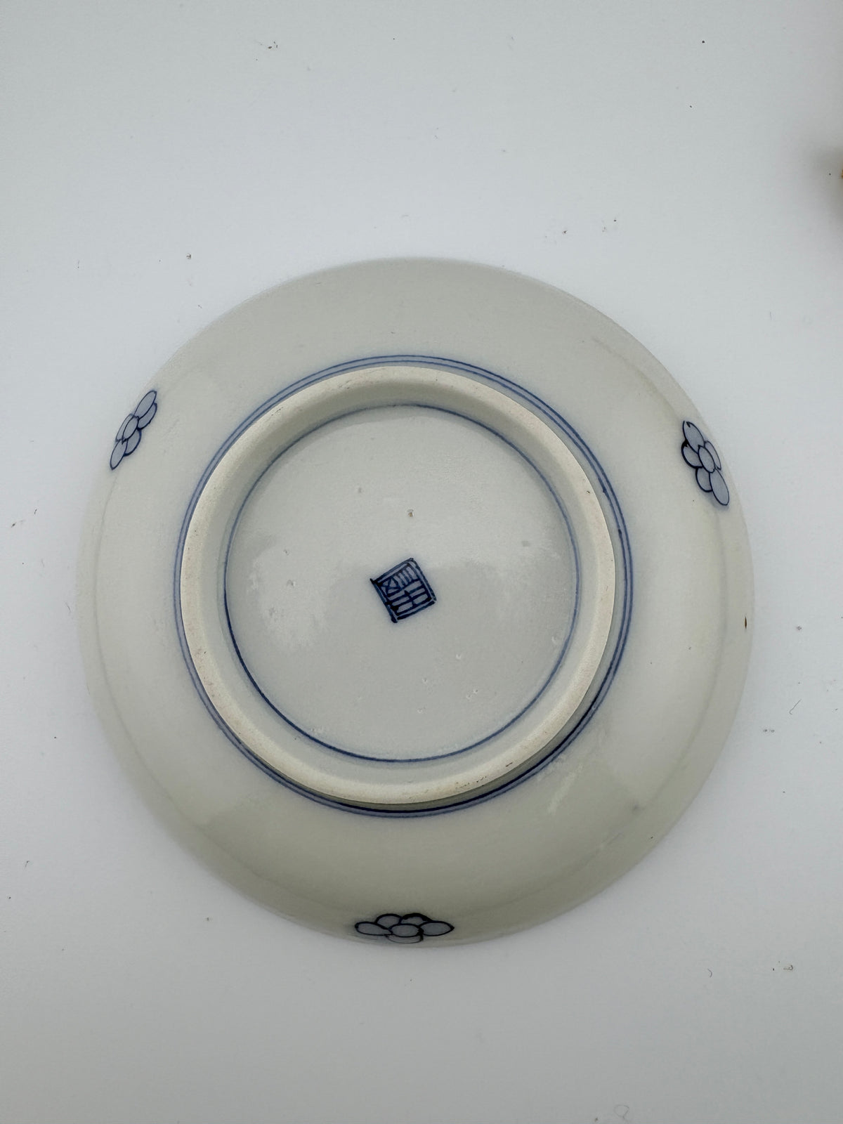 Meiji Imari iroe plate with stylised blossom motif, blue central medallion, and red‑green floral panels – Kotto Living