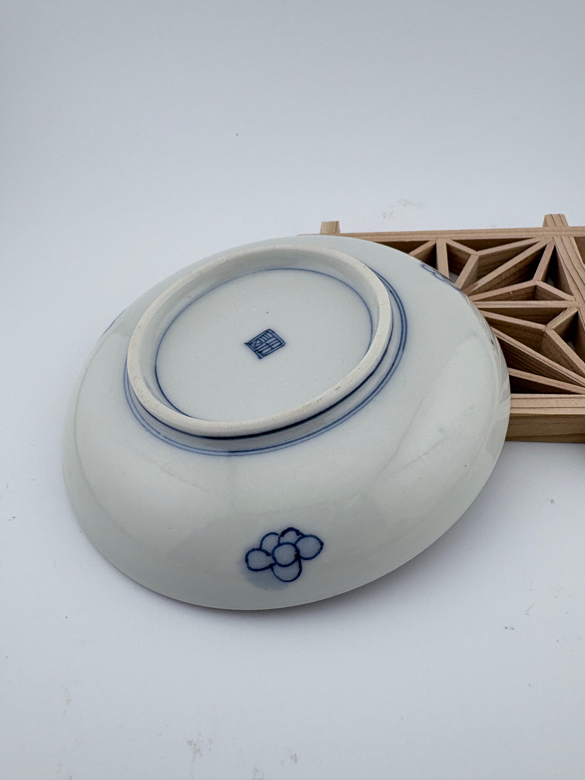 Meiji Imari iroe plate with stylised blossom motif, blue central medallion, and red‑green floral panels – Kotto Living